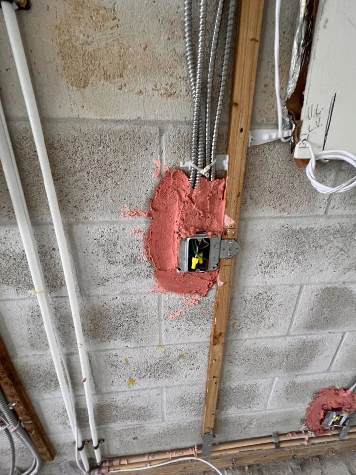 Close-up photograph of a firestopped box and conduit penetration